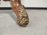 a close up of a wooden bench with gold decorations on it