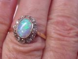 a woman ' s hand holding a ring with an oplite in it