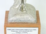 a silver statue of a man holding a dog on top of a wooden plaque