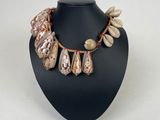 the necklace is decorated with shells and beads on a black mannequin