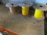 three spools of yellow thread sitting on a table