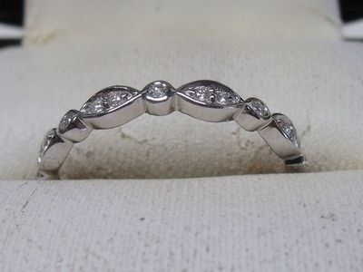 un gros plan d'une bague en diamant posée sur un tissu blanc
