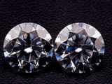 a pair of diamond cut diamonds on a black surface