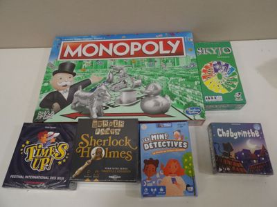 a monopoly board game on a table next to other games