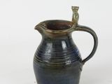 a blue and brown pitcher with a cat on it