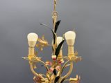 a close up of a chandelier with flowers and leaves on it