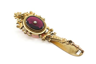 un gros plan d'un bracelet en or orné d'une pierre violette