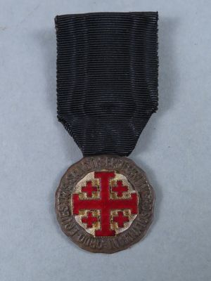 a close up of a medal with a red cross on it