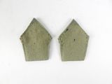 two pieces of green cloth with holes in them on a white surface