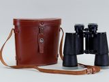 an old pair of binoculars with a leather case on a white background