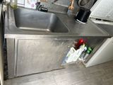 un évier en inox dans une cuisine équipée d'une cafetière