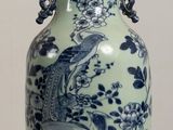 a blue and white vase sitting on a wooden table