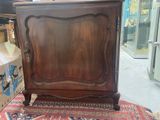 a wooden cabinet that is sitting on a rug