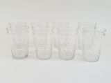 six clear glass drinking glasses lined up on a white surface