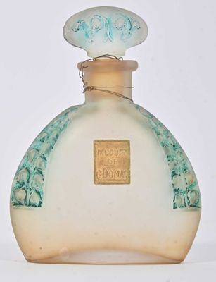 un flacon de parfum posé sur une surface blanche