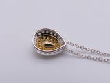 a close up of a silver and gold necklace on a white surface
