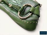 a green purse with a gold ring on it