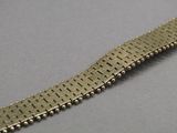 une photo en gros plan d'un bracelet en métal posé sur une table