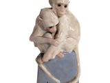 une figurine représentant un singe tenant un petit singe dans ses bras