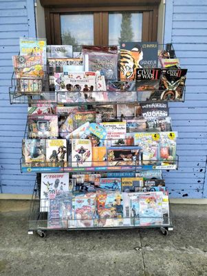 un chariot rempli de magazines devant un bâtiment bleu