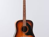 an old guitar hanging on a wall with a white background
