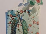 two peacocks sitting on a branch of a tree