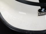 a white and black cake with a mickey mouse sticker on it
