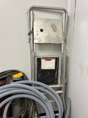 a hose that is attached to the wall next to a water heater