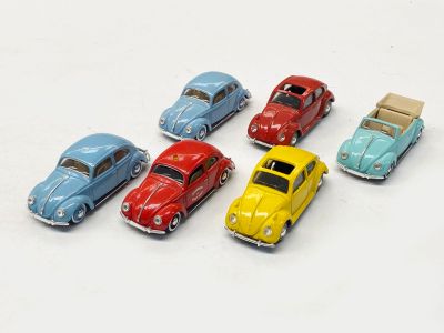 plusieurs petites voitures sont alignées sur une surface blanche