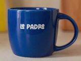 une tasse à café bleue sur laquelle est inscrit « le padre »