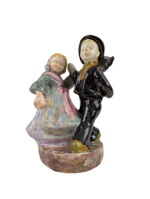 a figurine of a boy and a girl on a rock