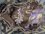 a purse that has a purple and gold design on it