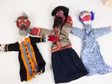 three cloth dolls laying on top of each other on a white surface