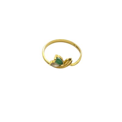 a close up of a gold ring with a green stone