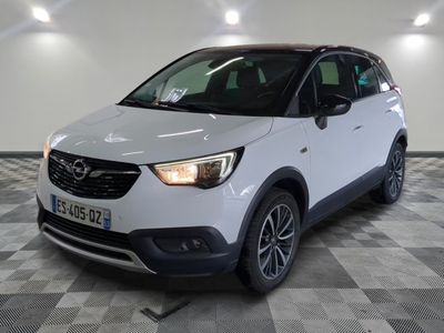 L'Opel blanche est garée dans une pièce au sol carrelé en damier.