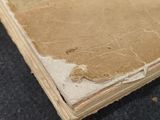 an old book with writing on it sitting on a table