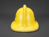 an old yellow fireman ' s helmet on a gray background
