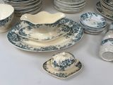a lot of plates and bowls and cups on the table