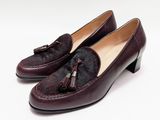 Les chaussures de cette femme sont en cuir et ornées de pompons.