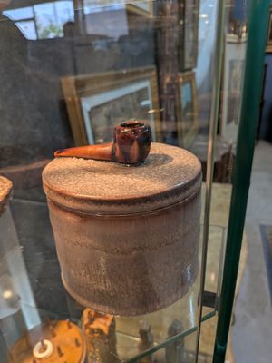 une vitrine en verre sur laquelle est posé un pot