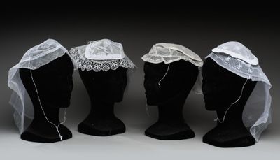 trois têtes de mannequin ornées de voiles et de dentelle