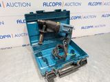 une boîte à outils bleue contenant une perceuse et son cordon d'alimentation