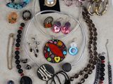 many different necklaces and bracelets laid out on the floor