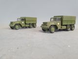 two toy army trucks sitting side by side on a table