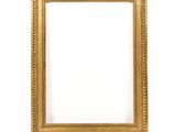 a gold frame on a white wall with a white background