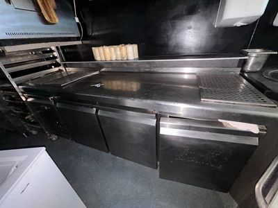 une cuisine équipée d'appareils électroménagers en inox et d'un évier