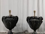 paire de lampes-urnes en marbre noir sur socles, rehaussées de touches dorées
