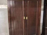 une armoire en bois qui se trouve à côté d'une vieille horloge