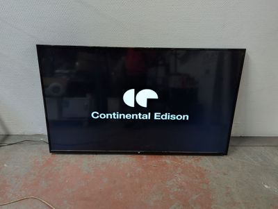 a flat screen television sitting on the floor in front of a wall