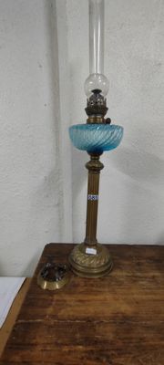 une petite lampe en verre bleu posée sur une table en bois